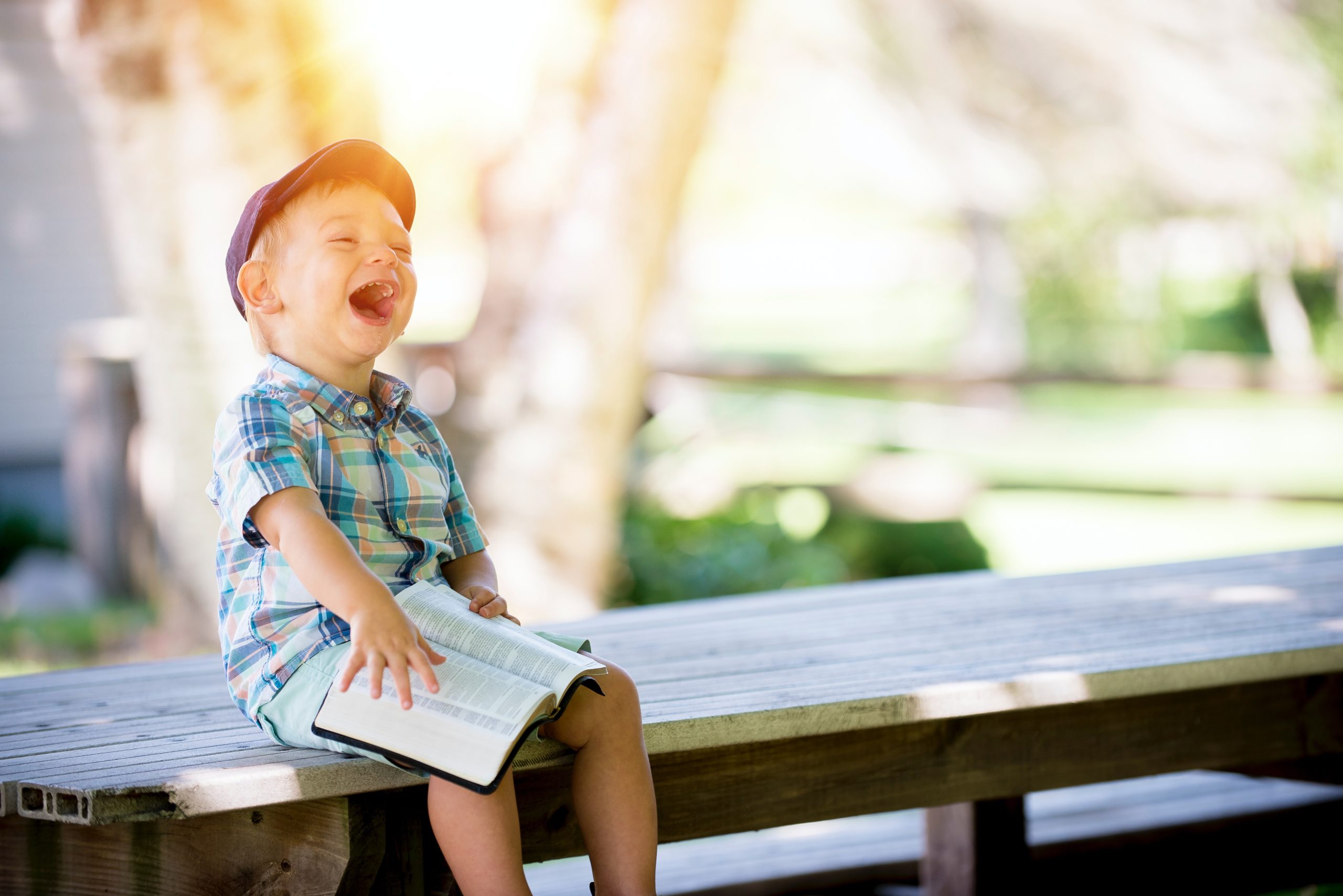 A young boy is confidently reading a book about embracing God's promises.